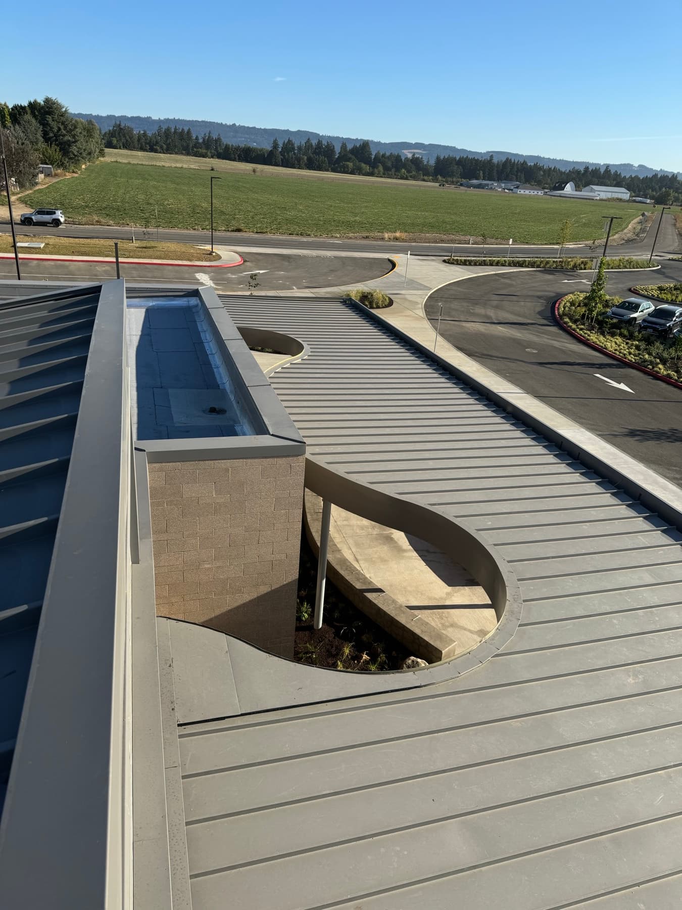 Metal roof with a round opening, with a green field and road in the distance