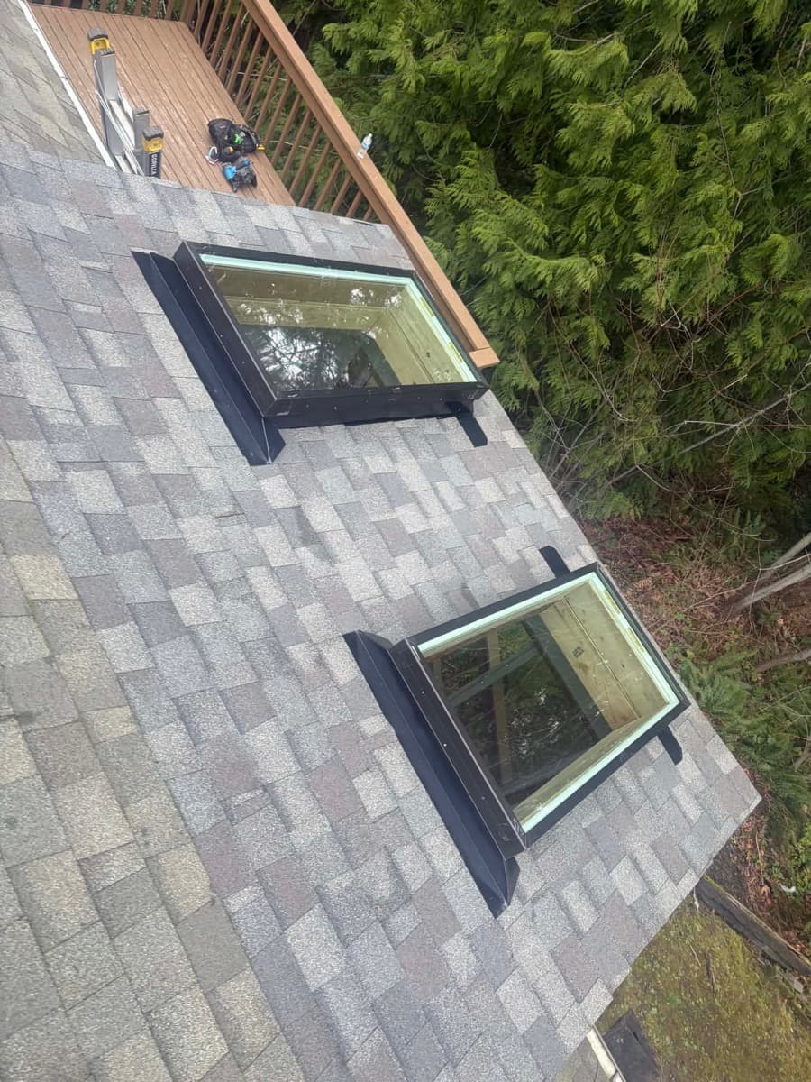 Two skylights with flashing set into a shingle roof, seen from above