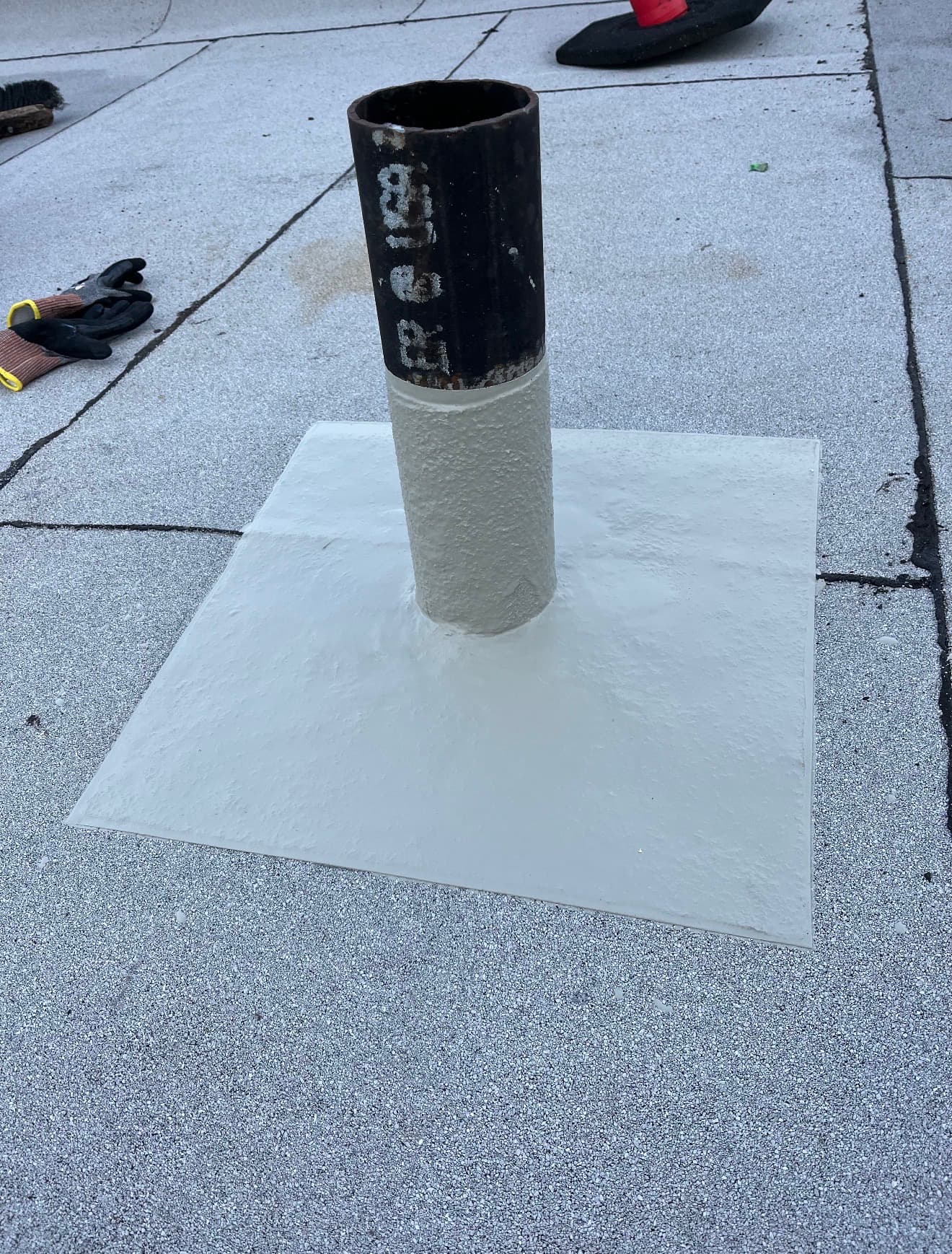 Pipe penetration with a flashing patch on a flat membrane roof
