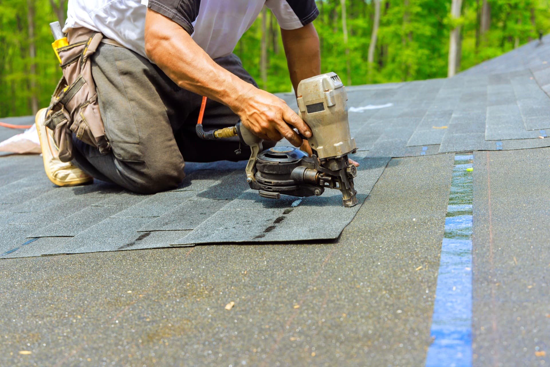 Roofer working on a storm-damaged roof in Renton, WA