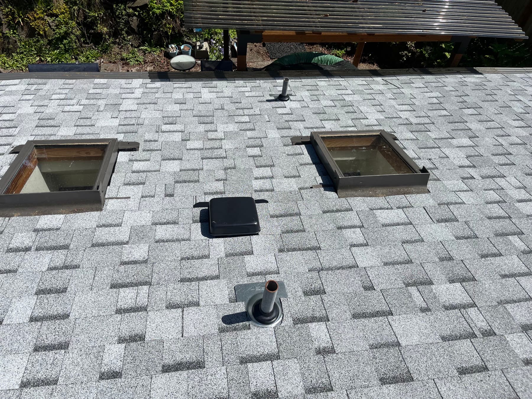 Roof surface seen from above, with two skylights, a vent and a pipe boot, the details an inspection checks